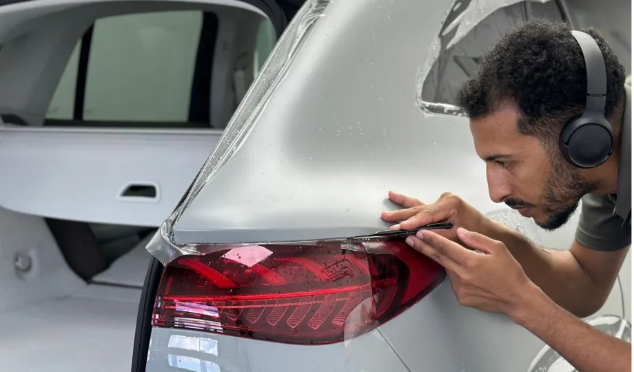 GenusCars expert installing protective film on car tail light